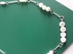 Un collier avec chaîne argentée, perles et perles lettres 